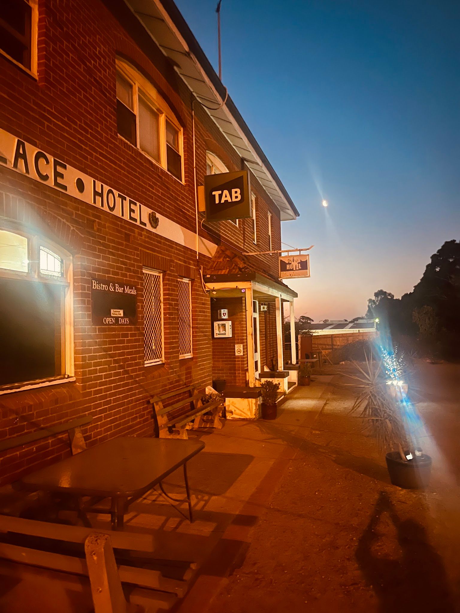 Palace Hotel Lang Lang exterior at dusk with outdoor seating