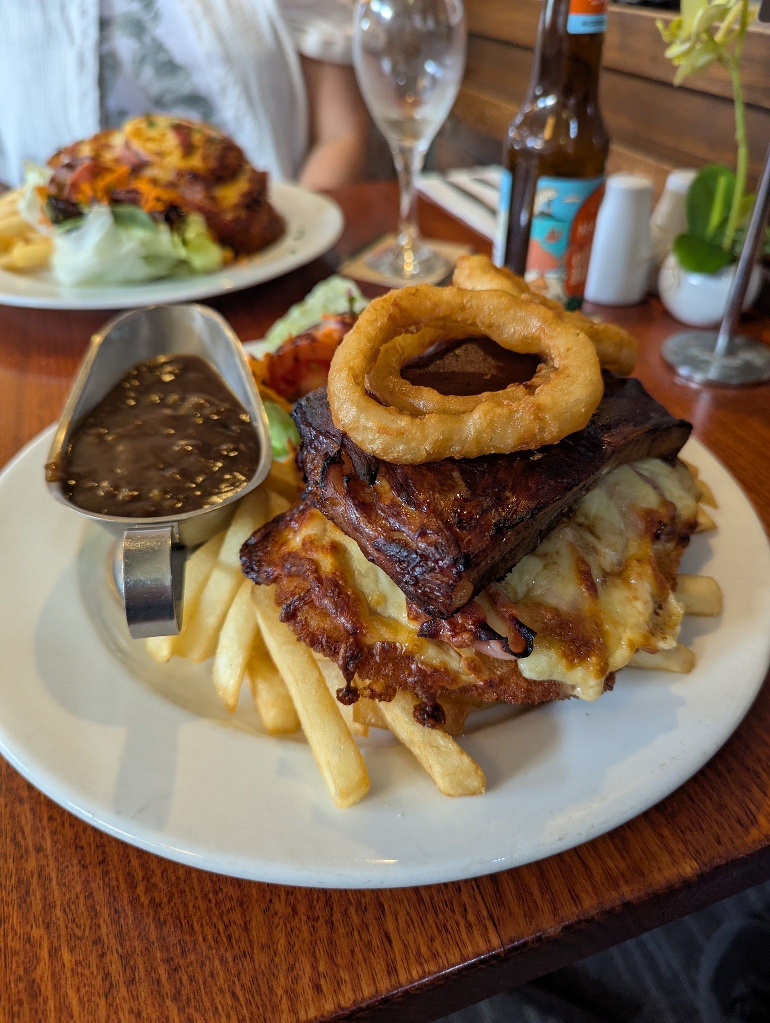 Stacked schnitzel with onion ring, chips and gravy jug